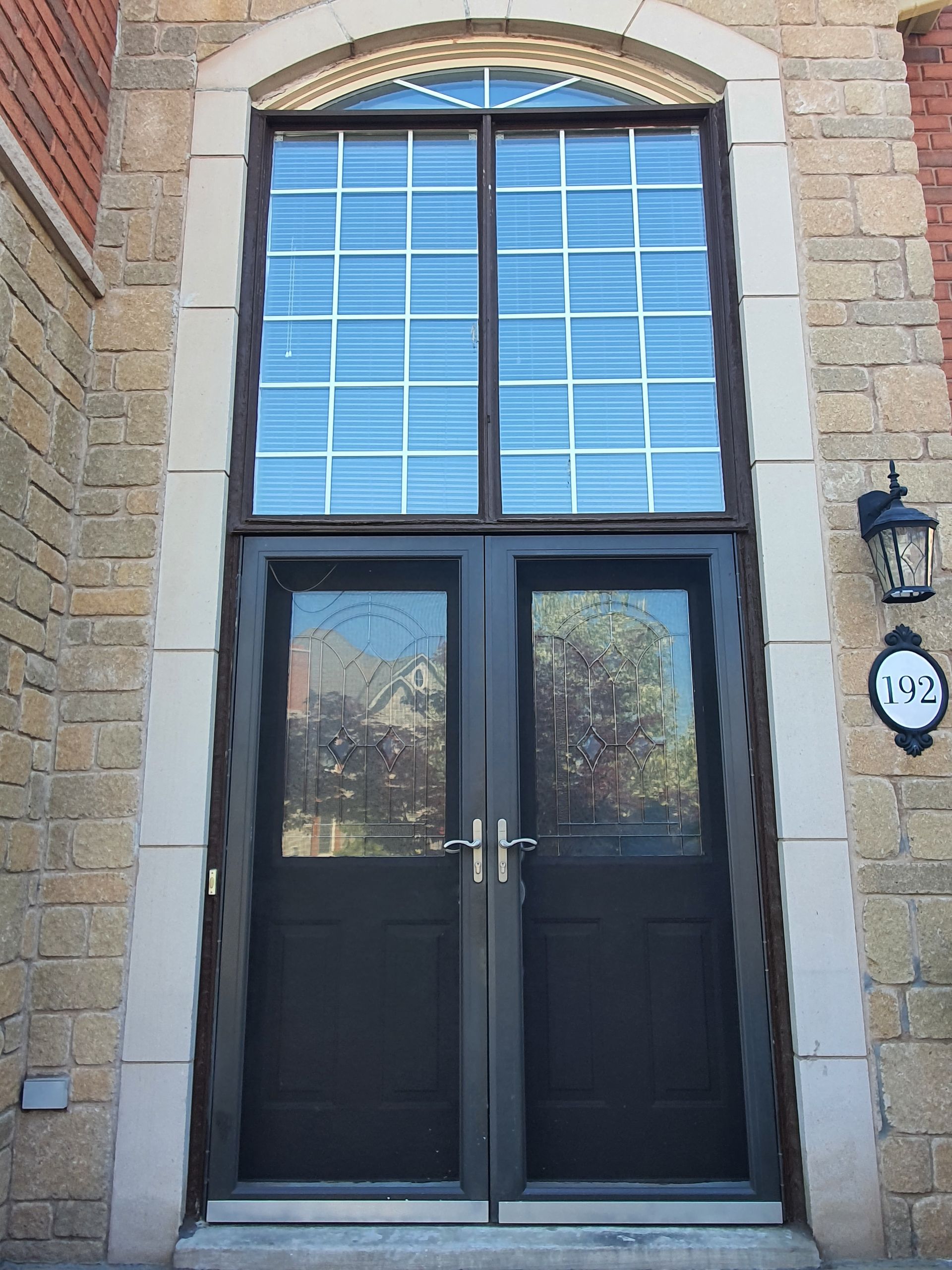 A brick building with a black double door