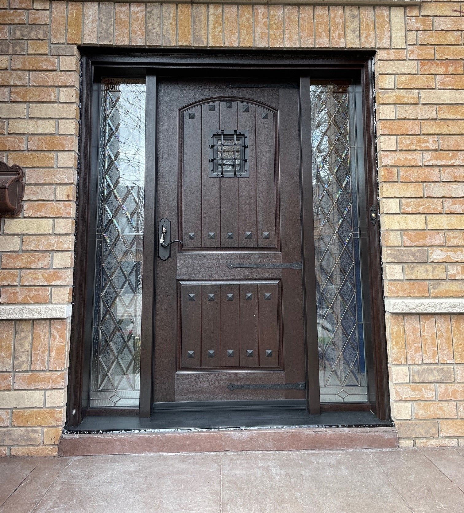 A brick building with a brown door and a mailbox