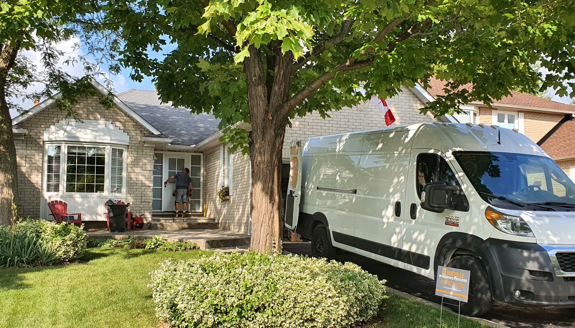 White service van parked in front of a suburban house with a tree and hedges in the yard