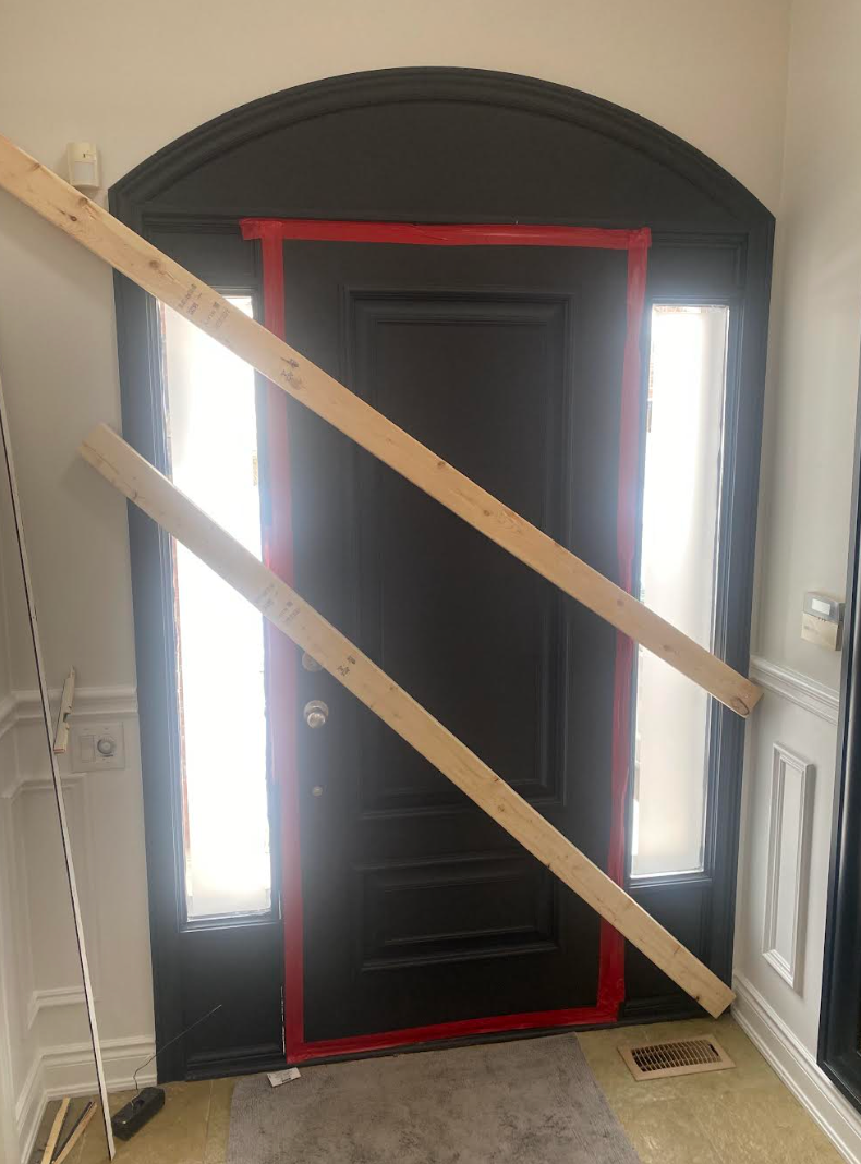 A white door with a stained glass fan above it