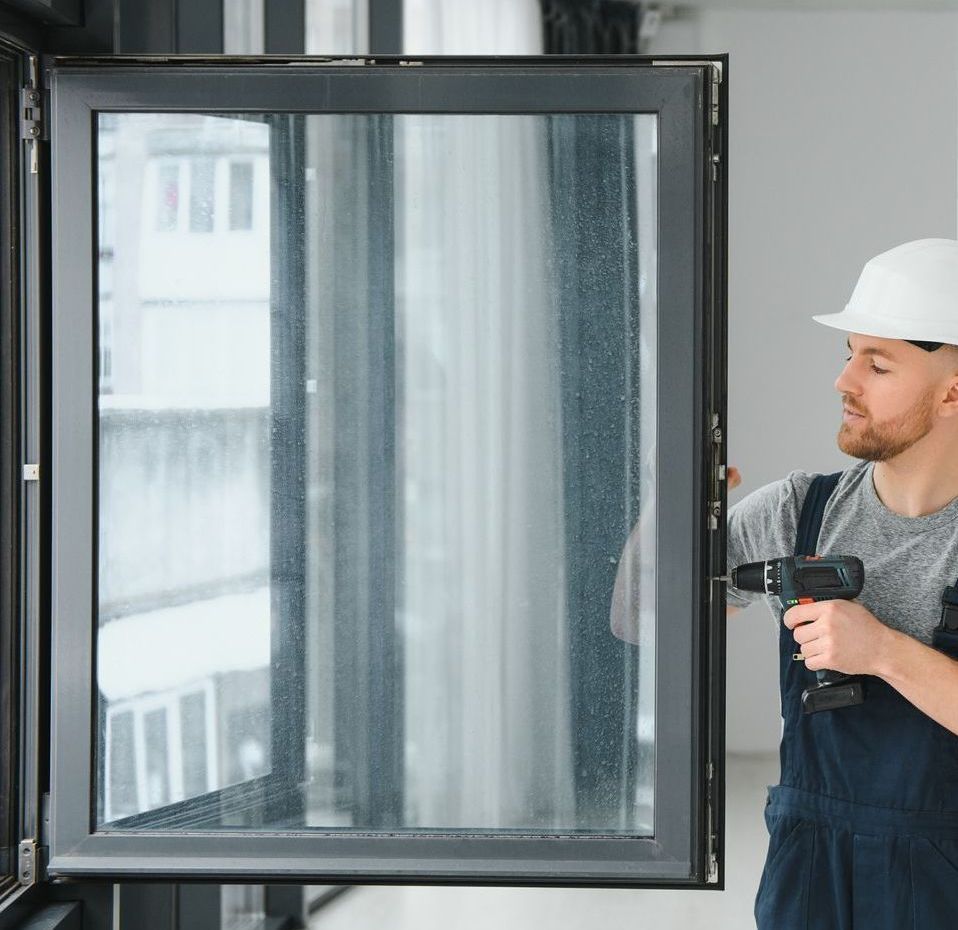 A man is installing a window with a drill.