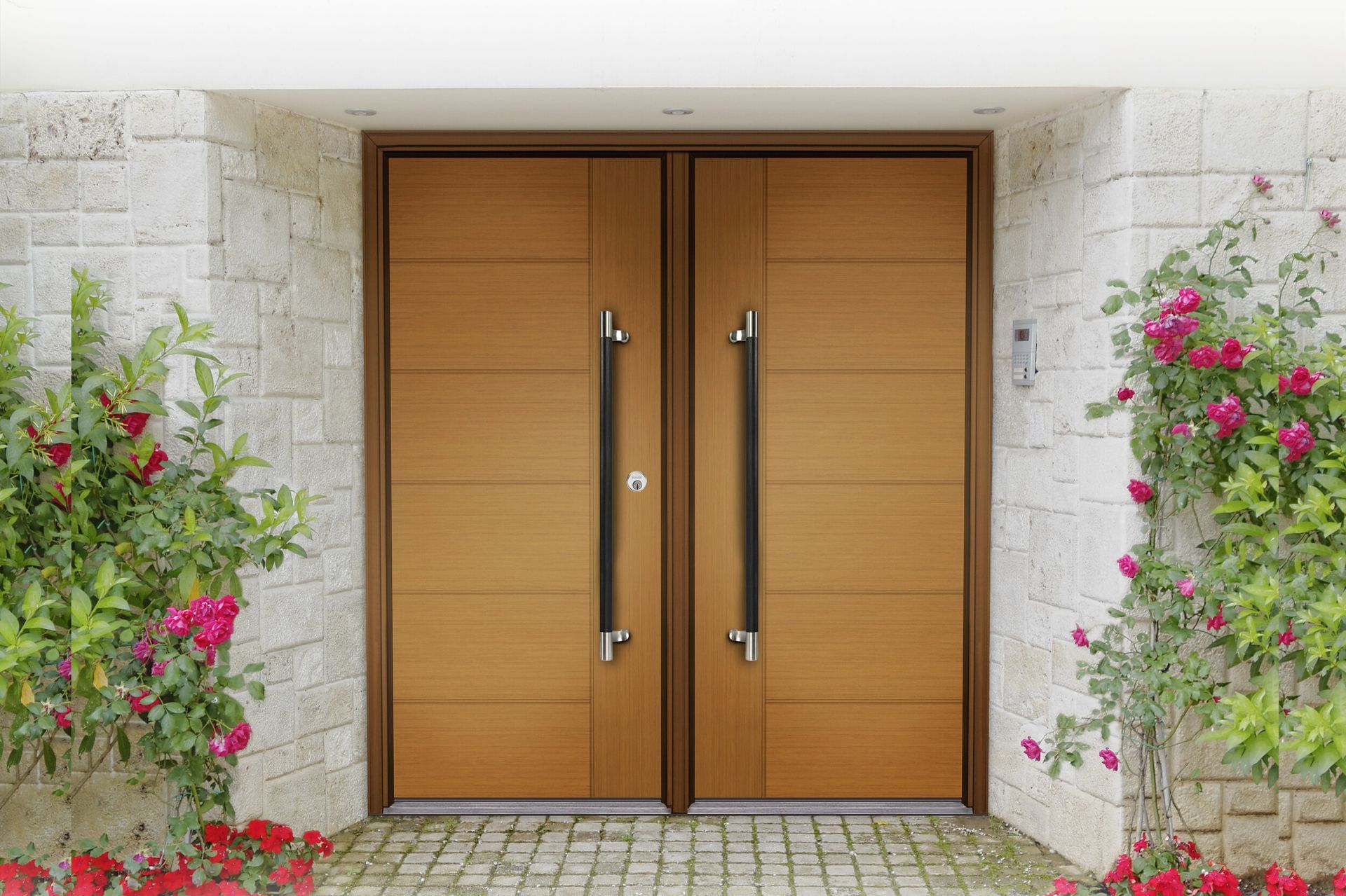 A pair of wooden doors with black handles on a brick wall.