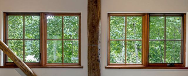A room with three windows and a wooden post