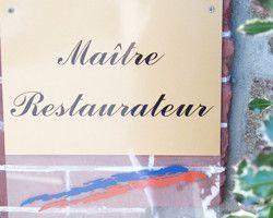 Un panneau sur un mur de briques qui dit maître restaurateur.