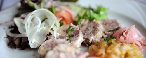 Un gros plan d'une assiette de nourriture avec de la viande et des légumes sur une table.