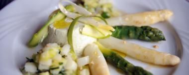 Une assiette blanche garnie d'asperges et d'autres légumes