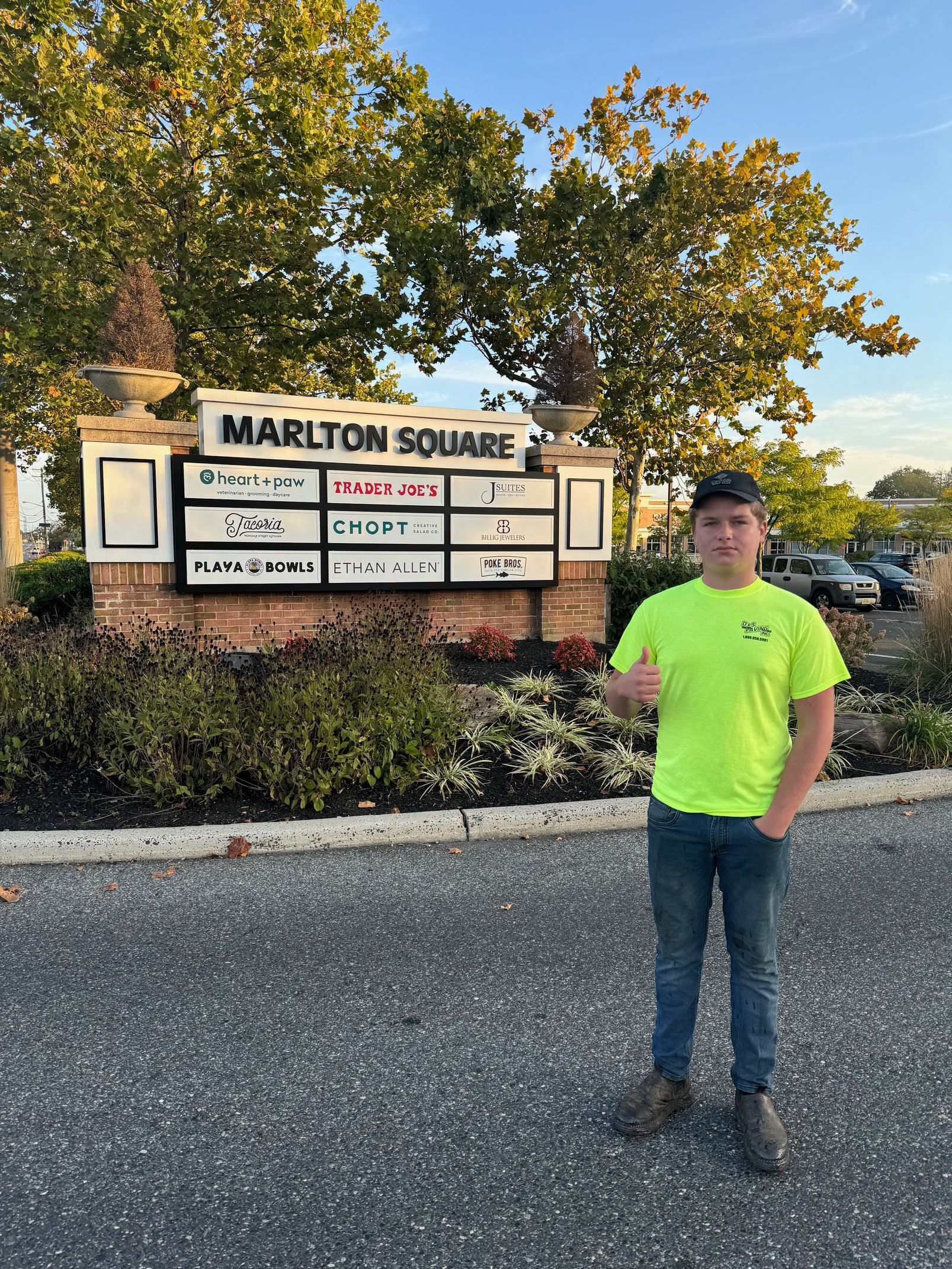 A Man in A Neon Yellow Shirt Is Standing in Front of A Sign.