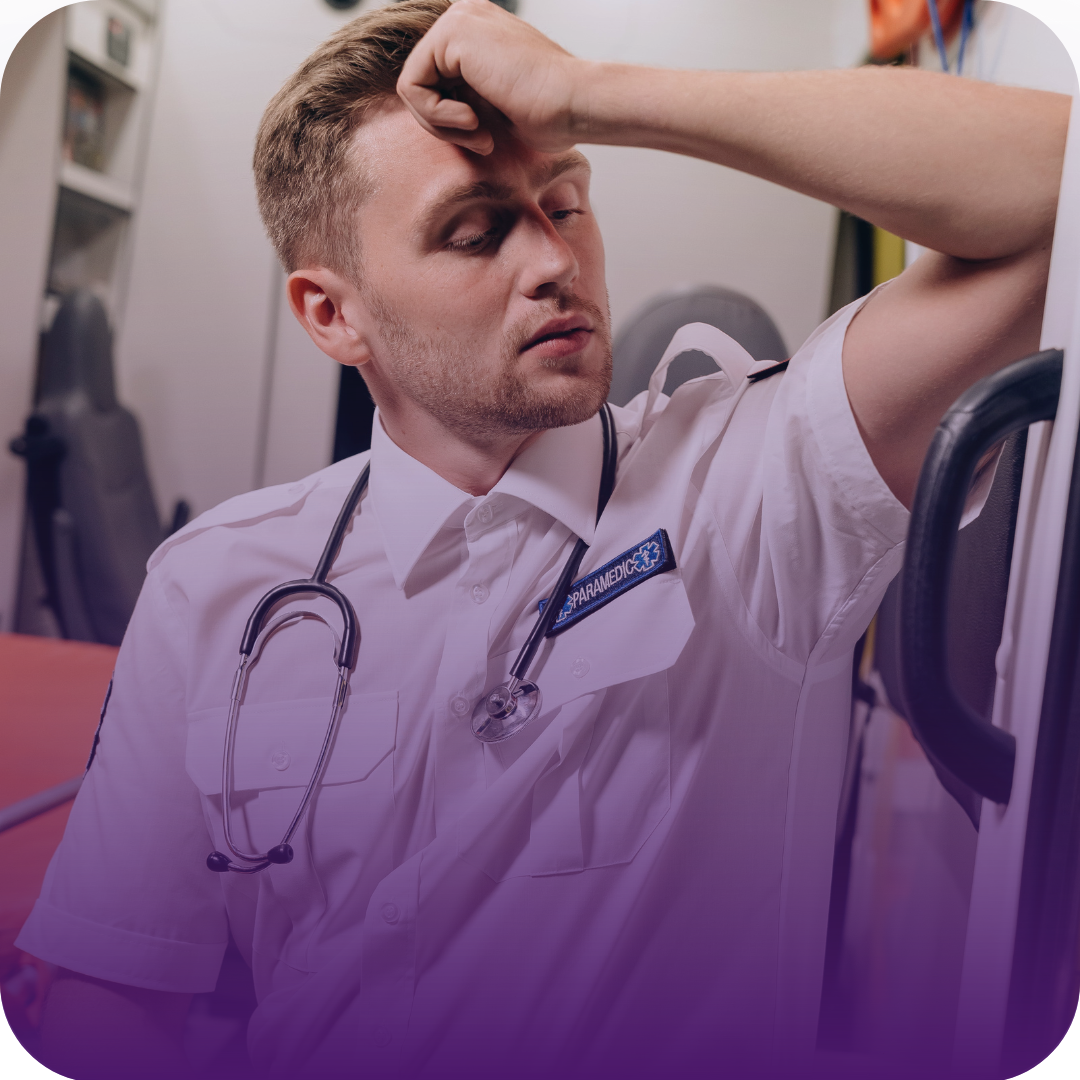 Paramedic looking stressed, leaning against ambulance door, stethoscope around neck.