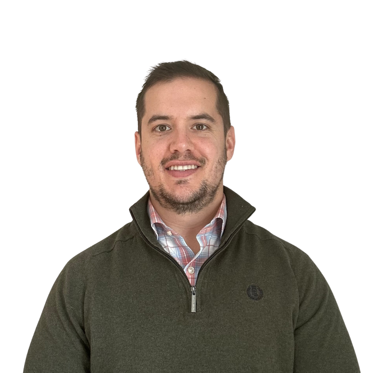 Man smiling in a green zip-up sweater over a patterned shirt, against a white background.