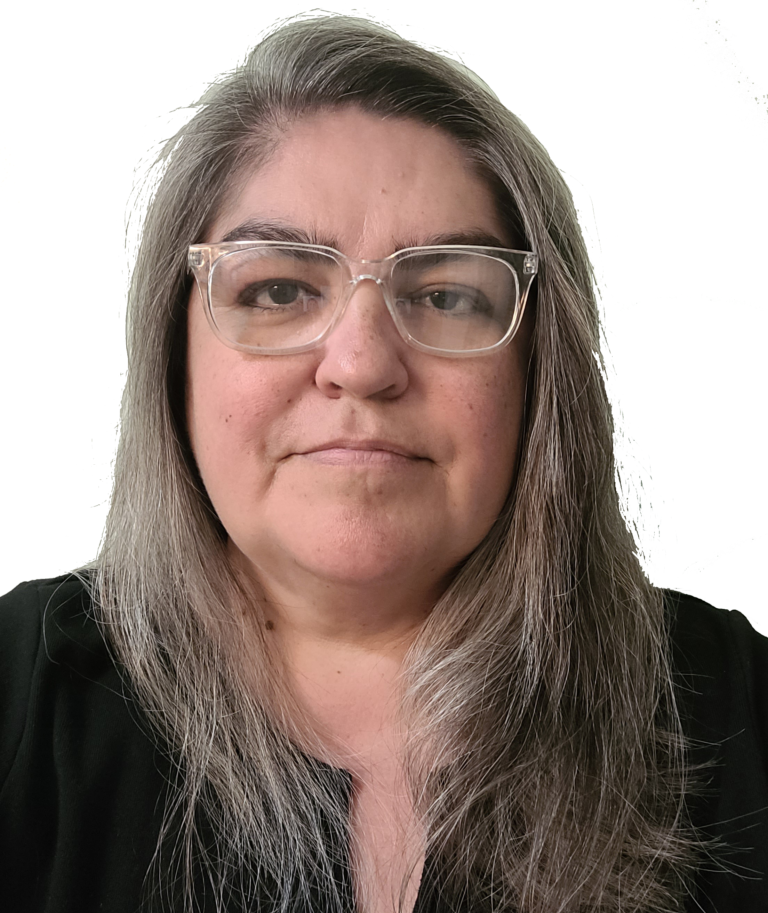 Woman with gray hair and glasses, wearing a dark top, against a white background.