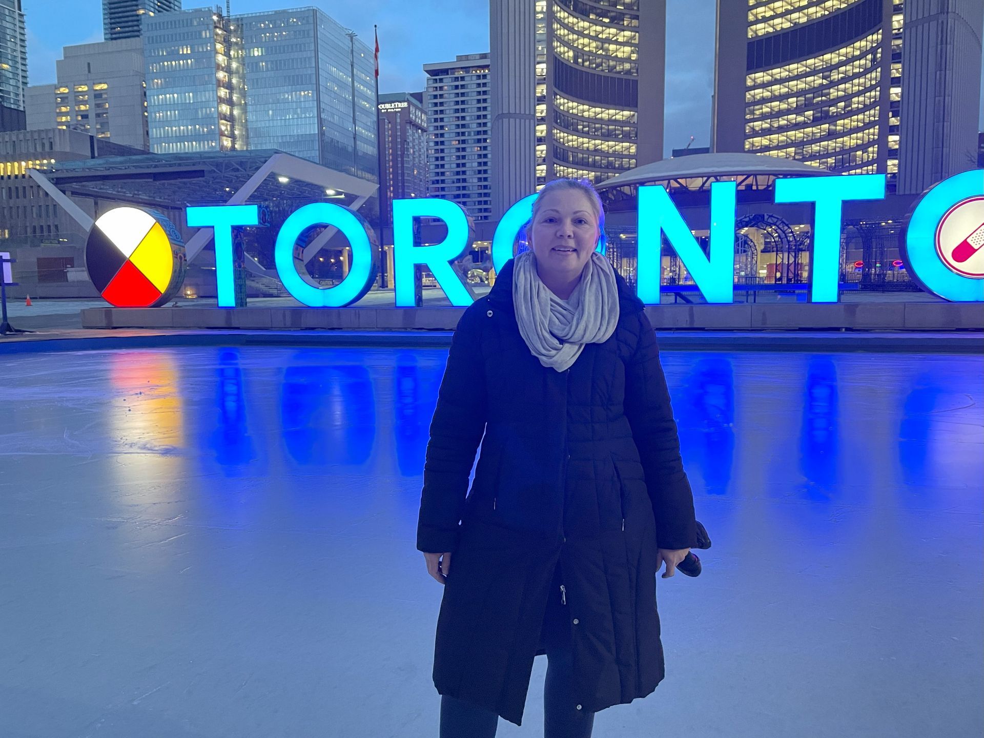Woman on an ice rink in front of the illuminated 