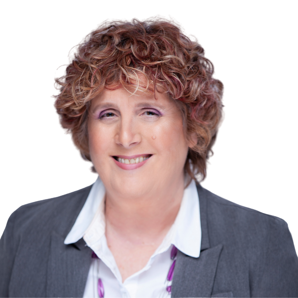 Woman with curly brown hair smiling, wearing a gray blazer and white shirt.