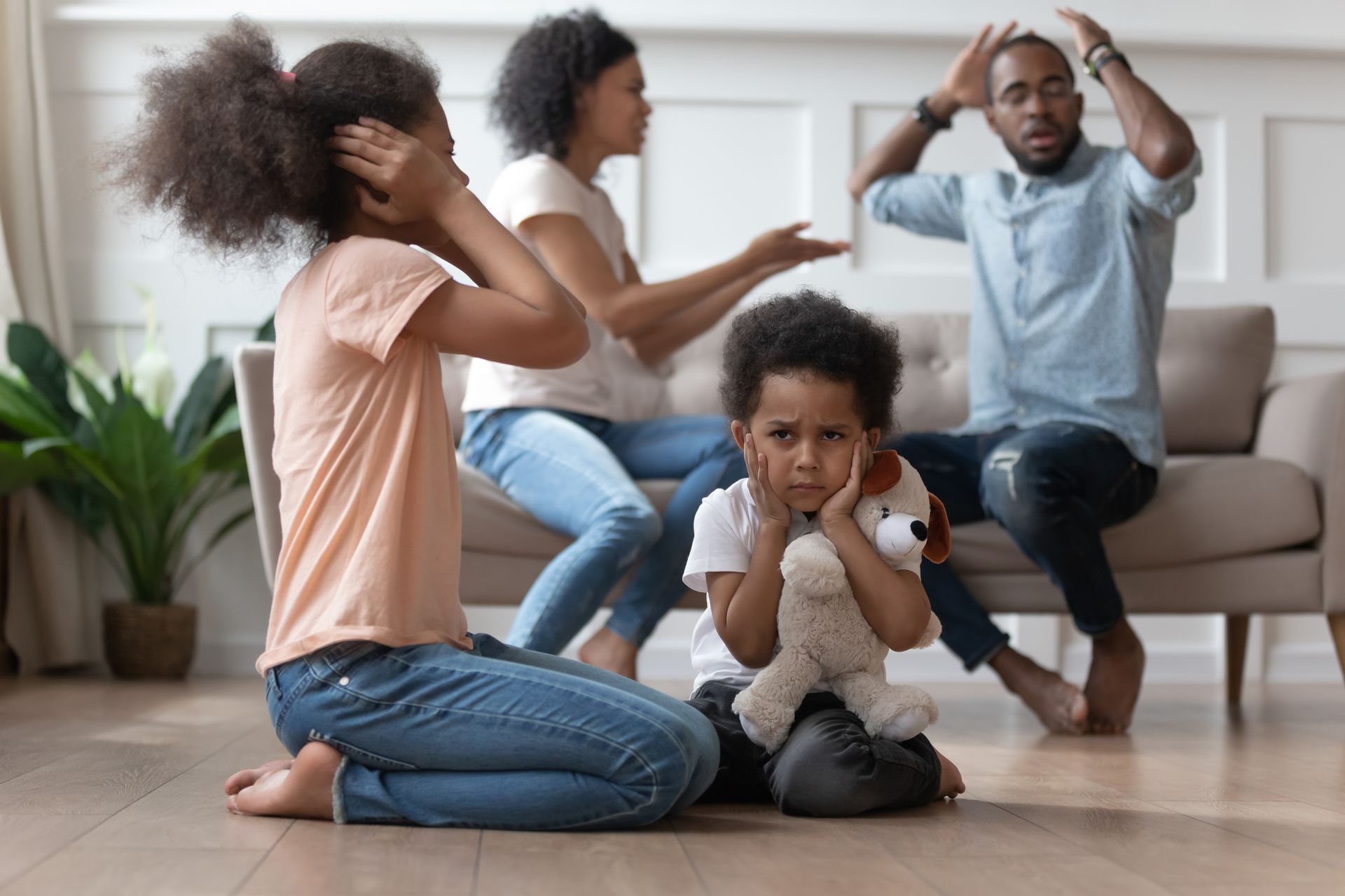 Family arguing in living room; children covering ears, adults gesturing angrily.