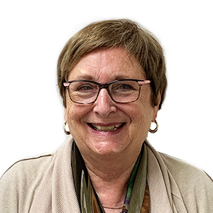 Woman with glasses smiling, wearing a light-colored sweater and scarf.