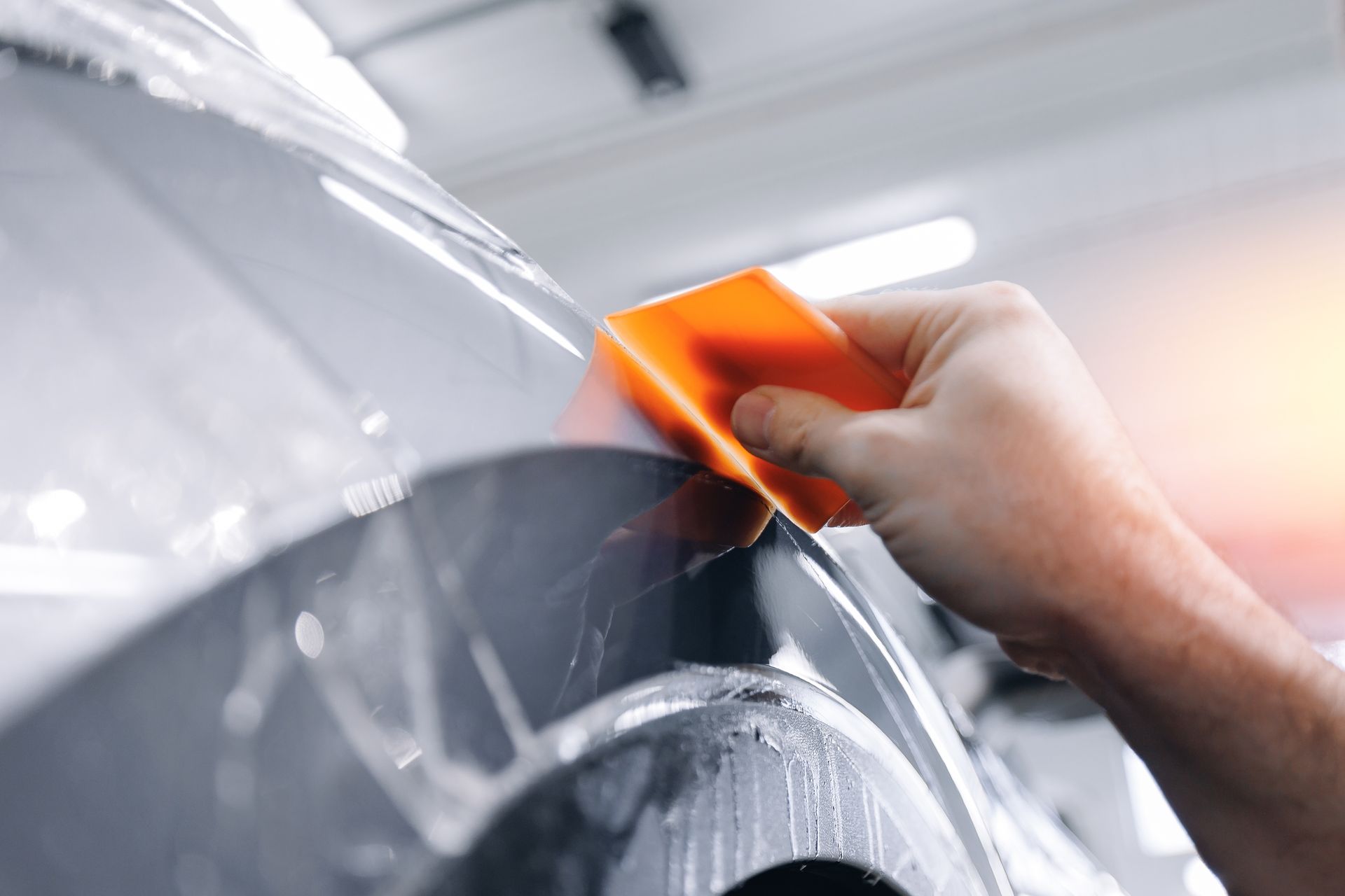 A man is working on a blue car in a garage.