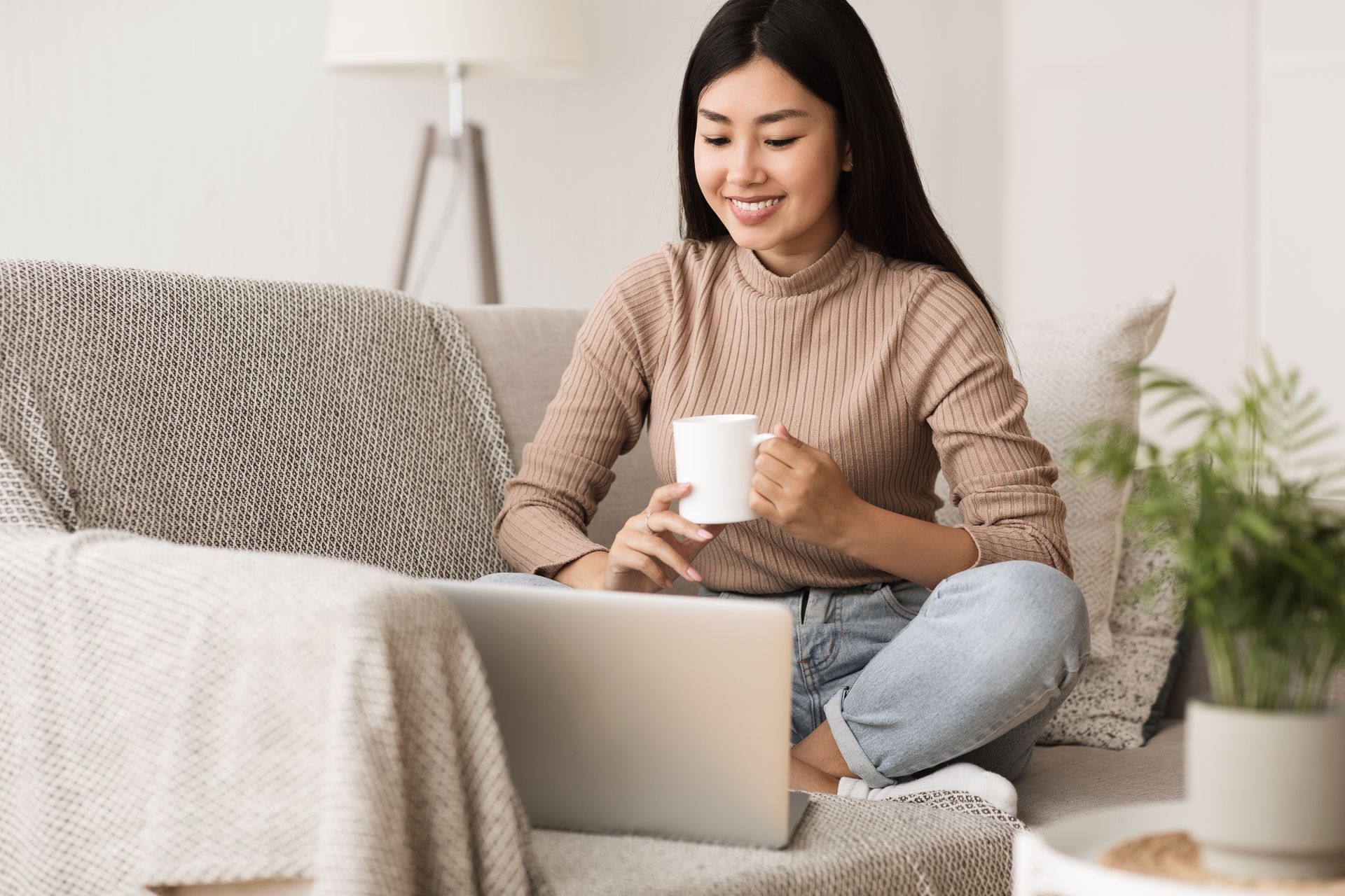 Woman sitting at a table looking at her laptop