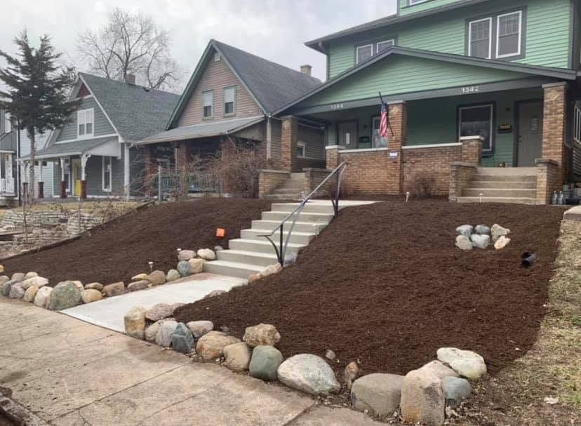 Two houses with newly landscaped front yards, retaining stones, and a central stairway up to a porch.