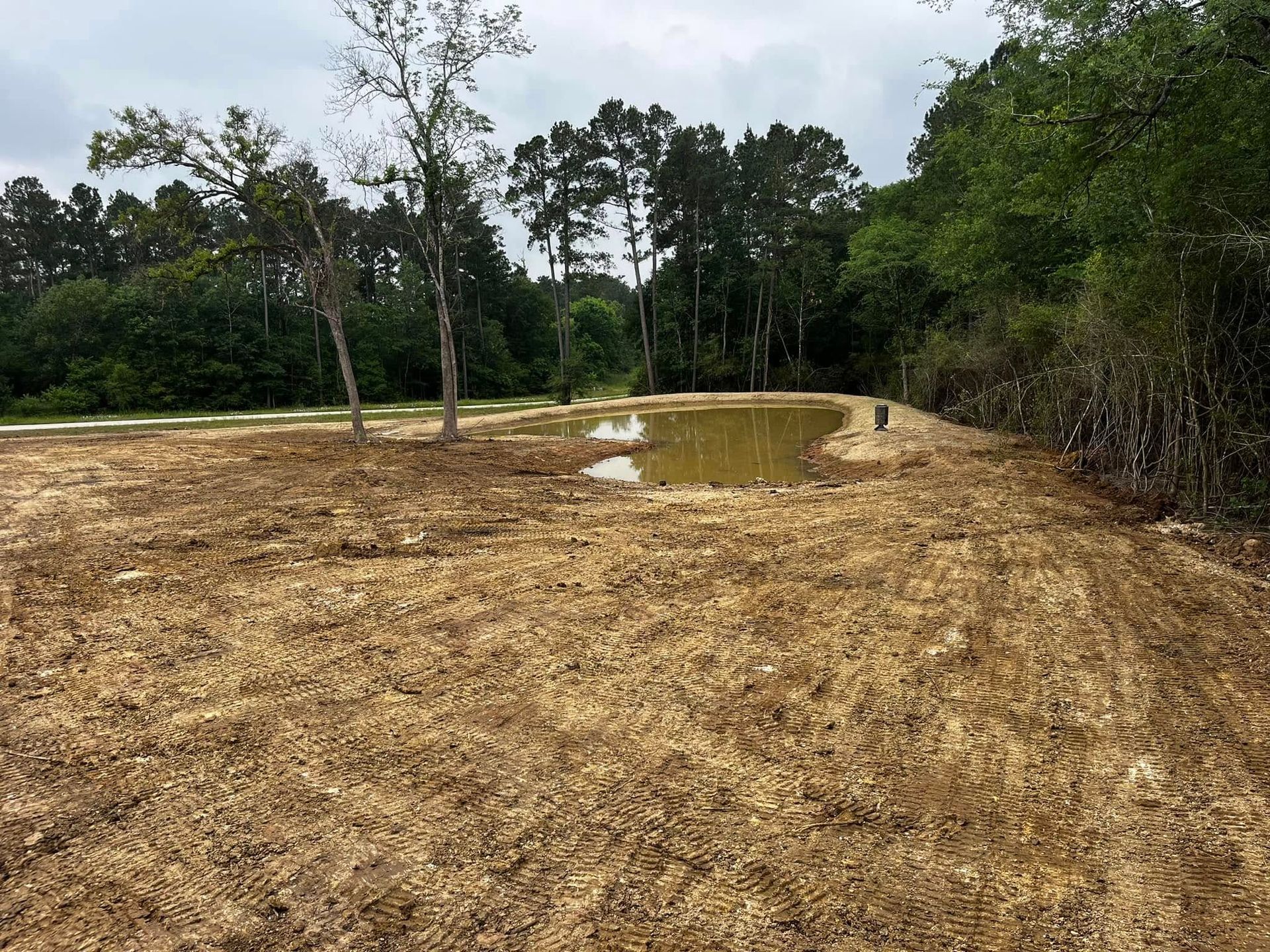 Ground view of finished pond with water after construction