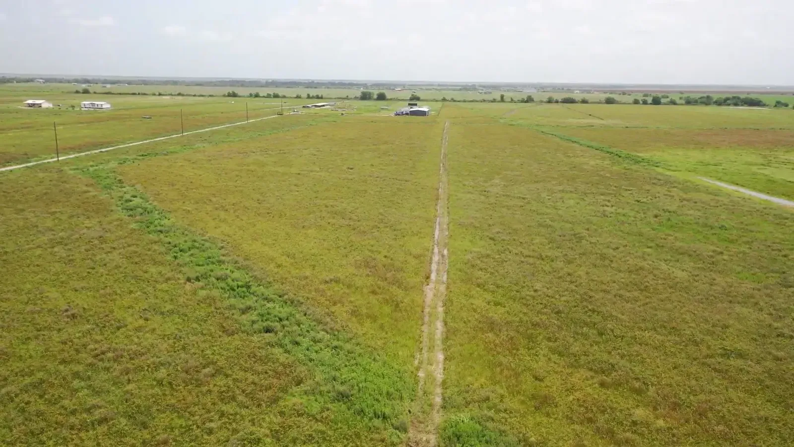 Aerial view of former rice-field acreage before pond excavation and land grading in Cat Spring, Texas