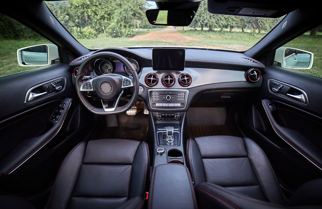 The interior of a car with black leather seats and a steering wheel.