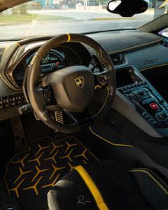 The interior of a lamborghini aventador with a steering wheel and dashboard.