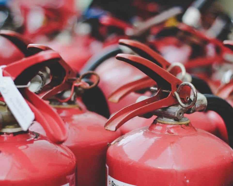 Red fire extinguishers with red handles, ready for use.