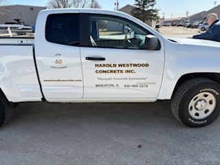 White Harold Westwood Concrete Inc. pickup truck parked on a snowy street