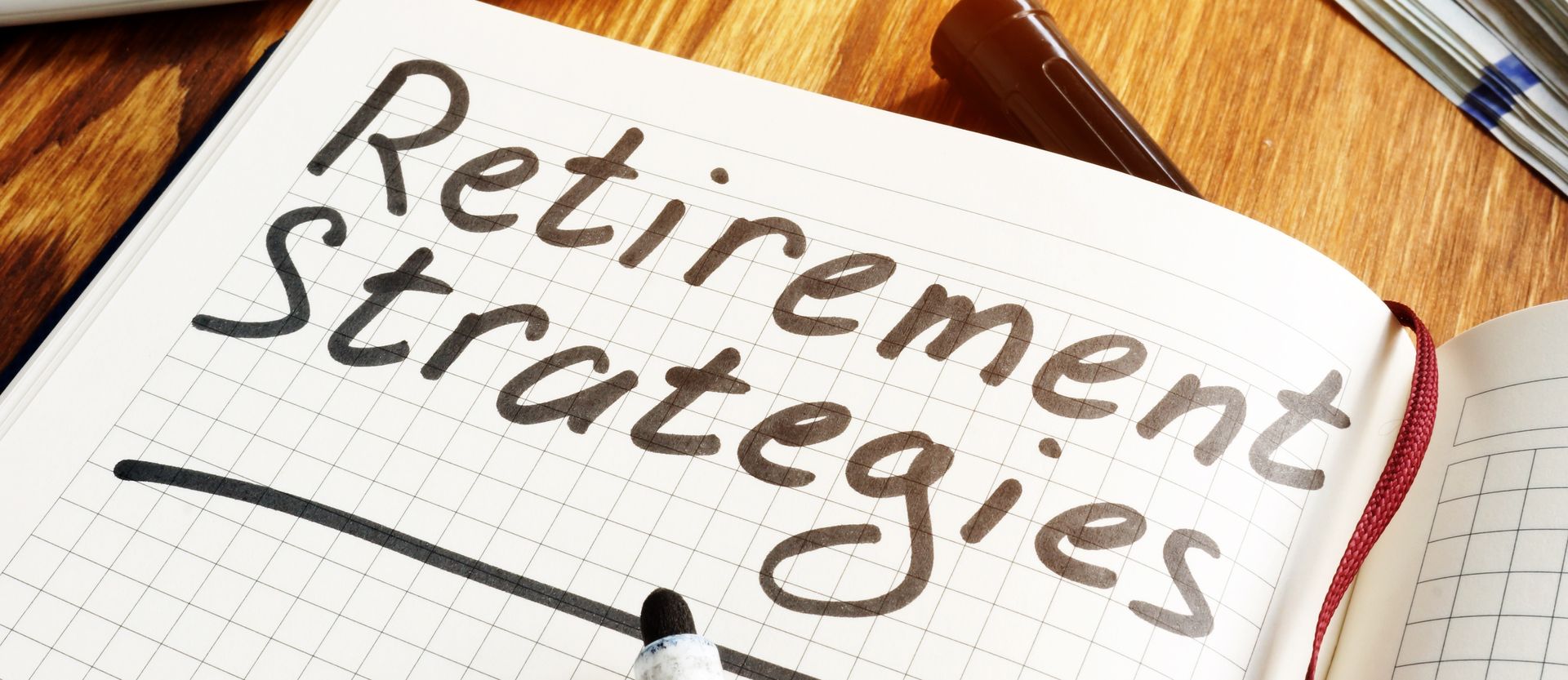 Notebook page with handwritten “Retirement strategies” on a desk