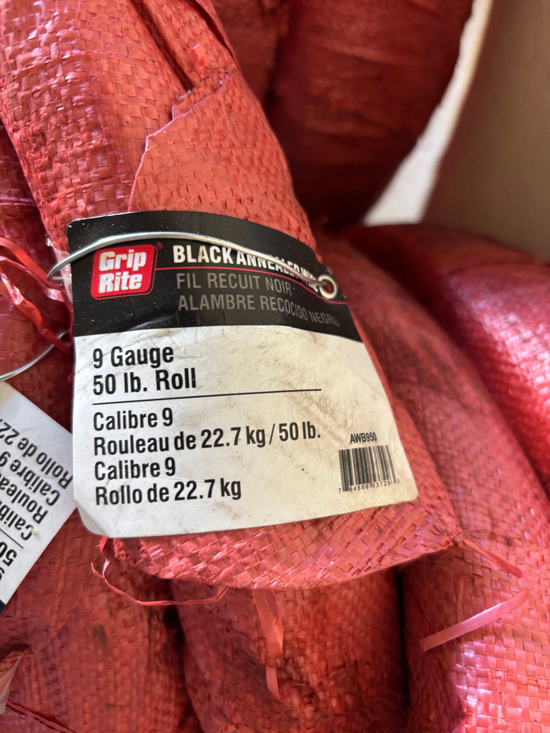 Red roll of Grip Rite black annealed wire mesh with product label in French and English