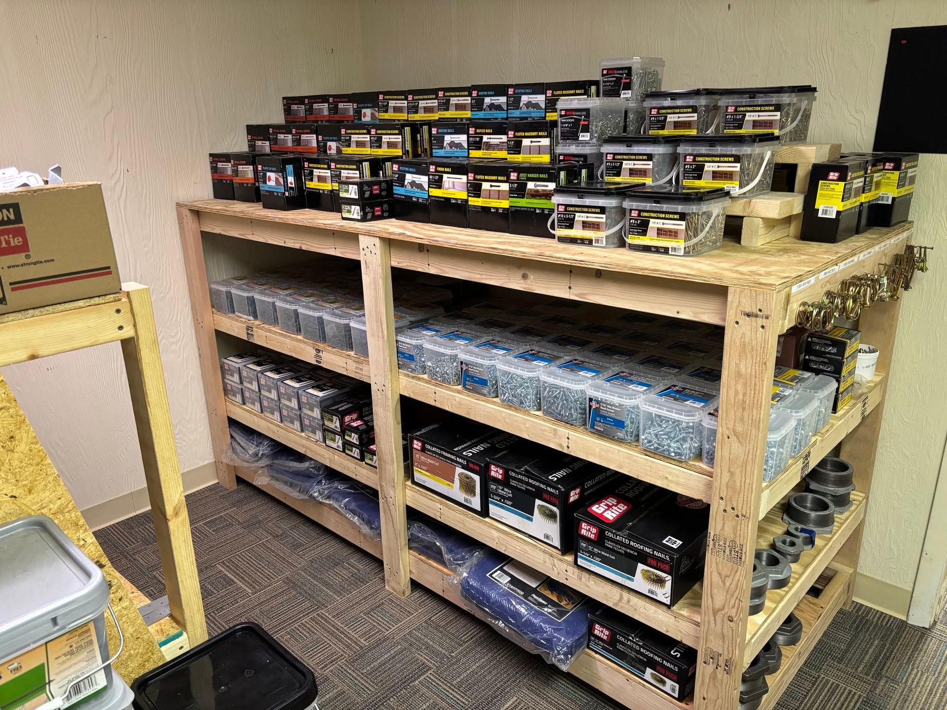 Wooden shelves stocked with rows of electronic parts and small boxes in a workshop room