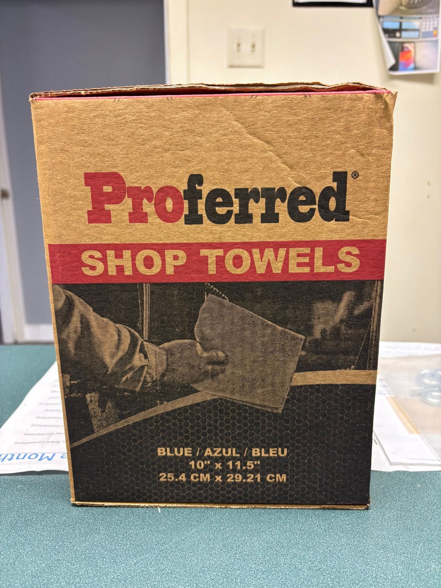 Box of Preferred shop towels with tan and red labeling on a table