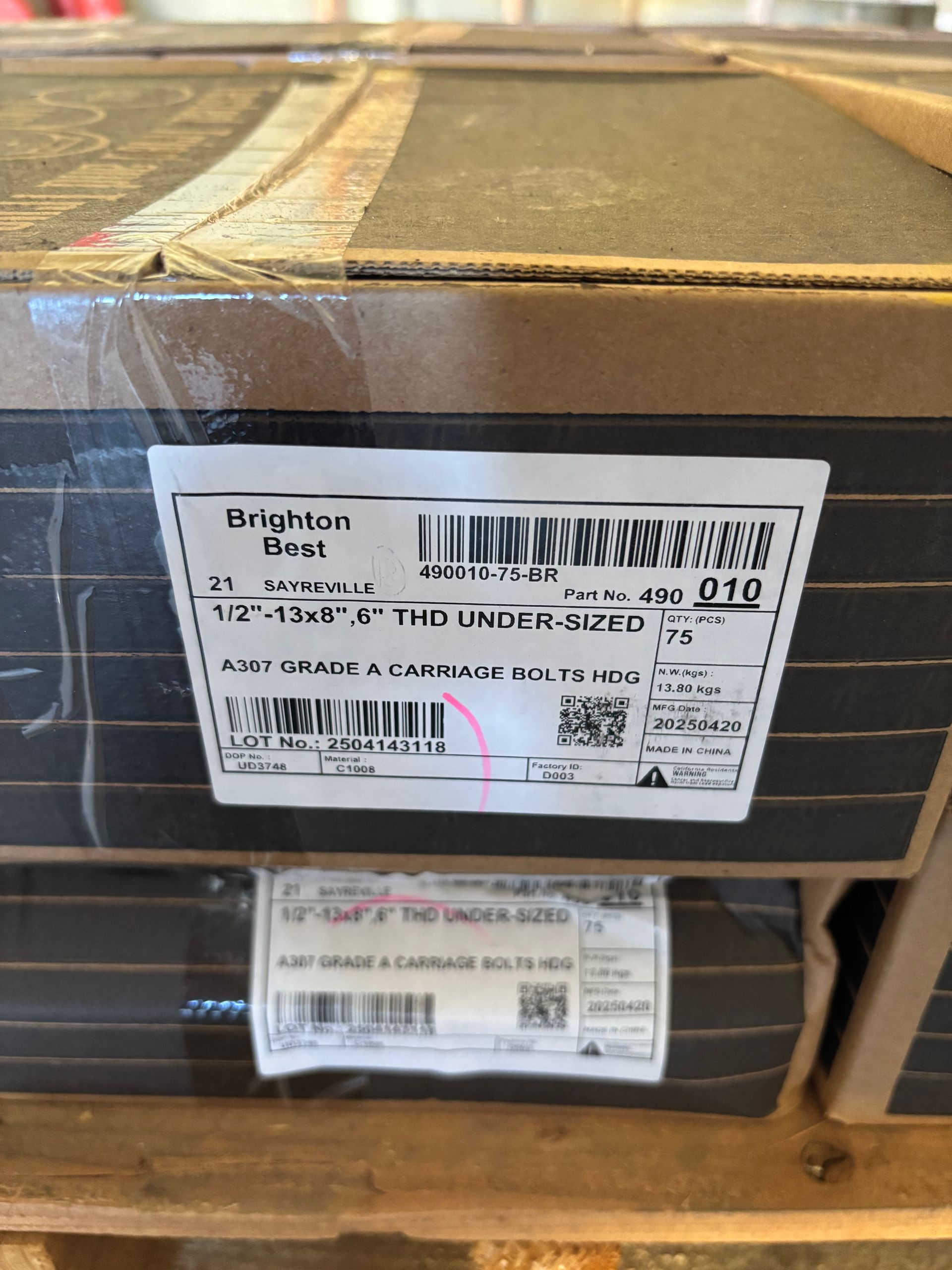 Stacked cardboard boxes on a wooden pallet with shipping labels and barcodes.