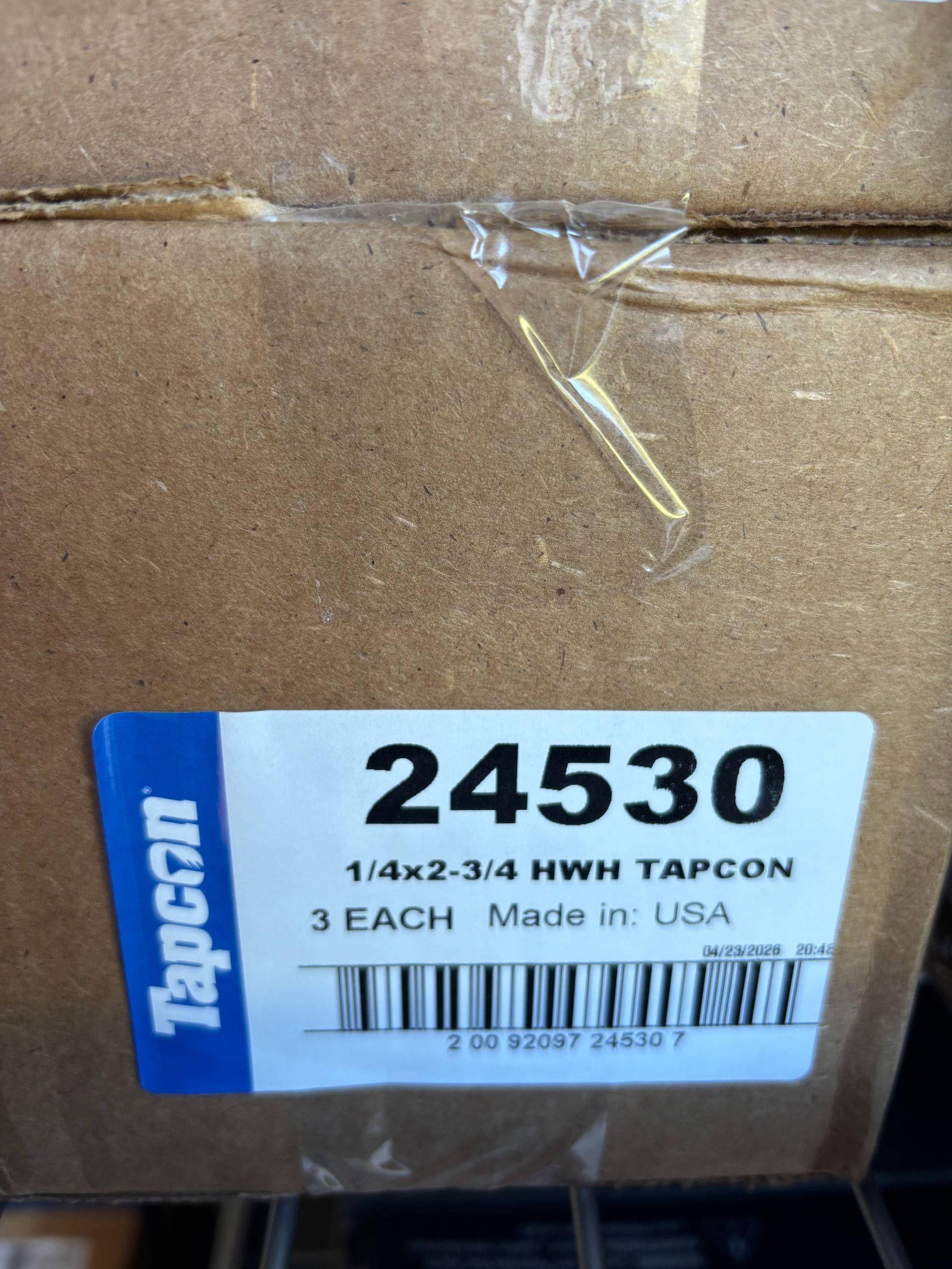 Close-up of a brown box with a blue and white Tapcon label reading 2430.