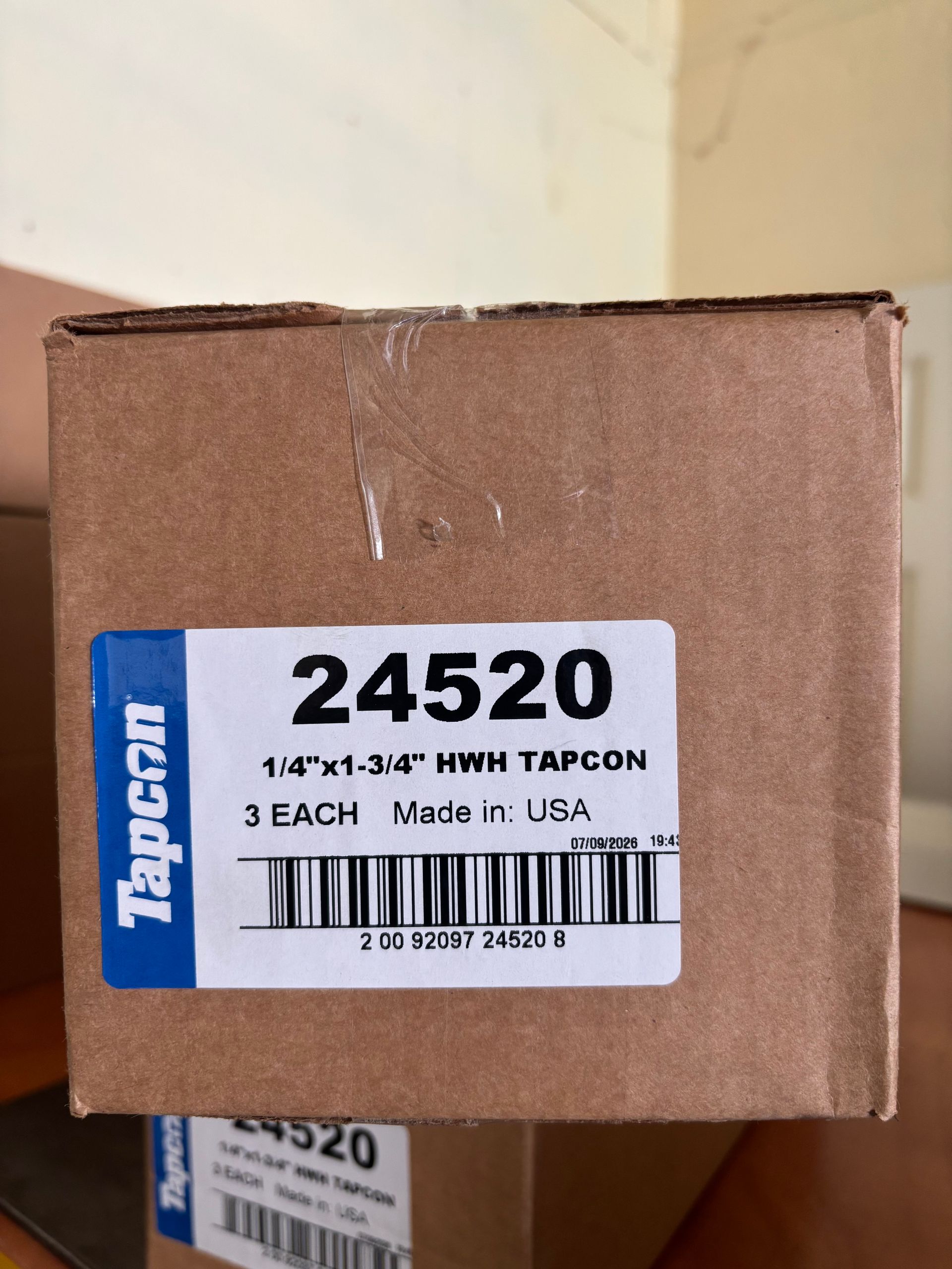 Brown cardboard box with a blue-and-white label reading 24520 and “1-3/4 x 1-1/4” wood screws.