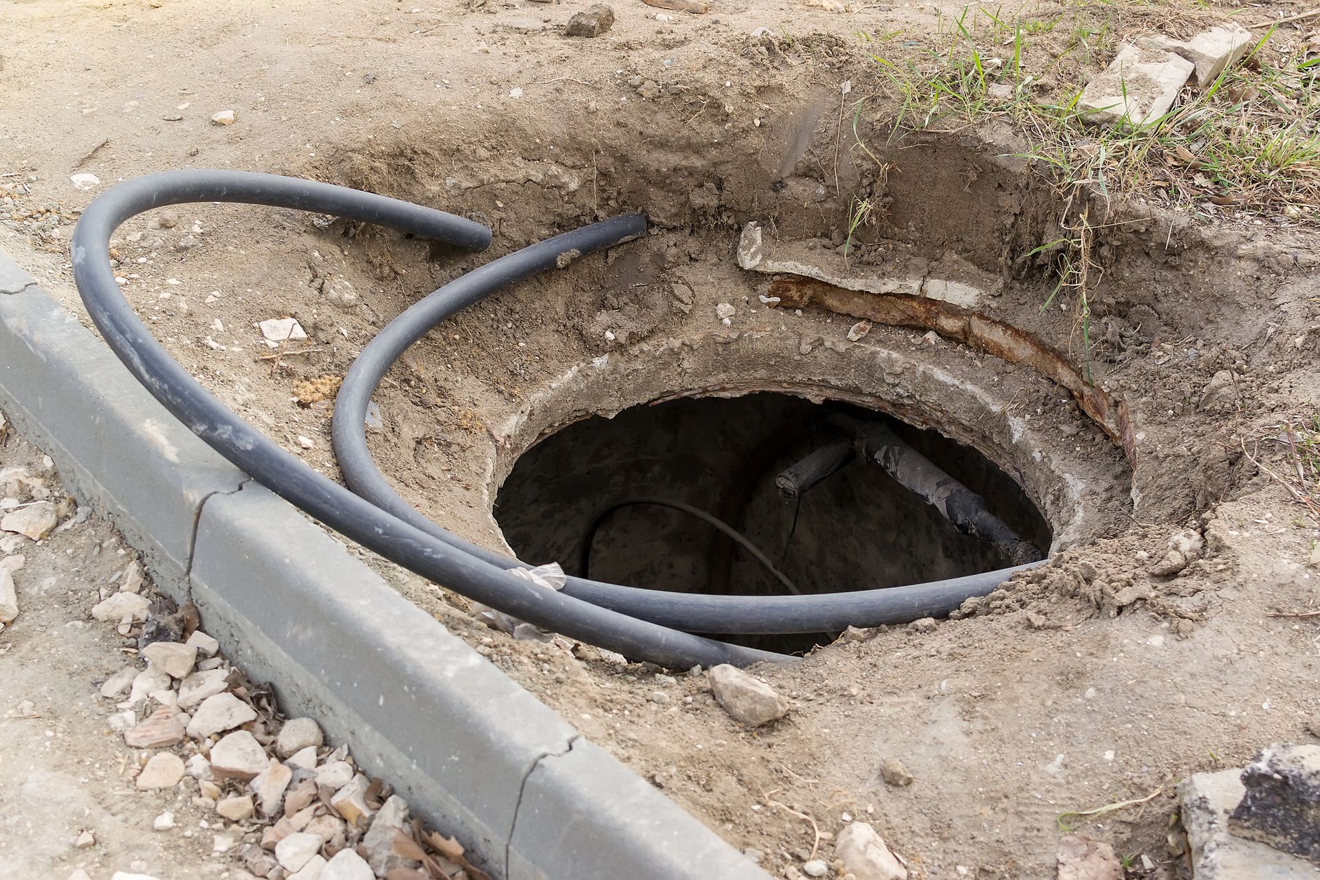 A hole in the ground with a hose coming out of it
