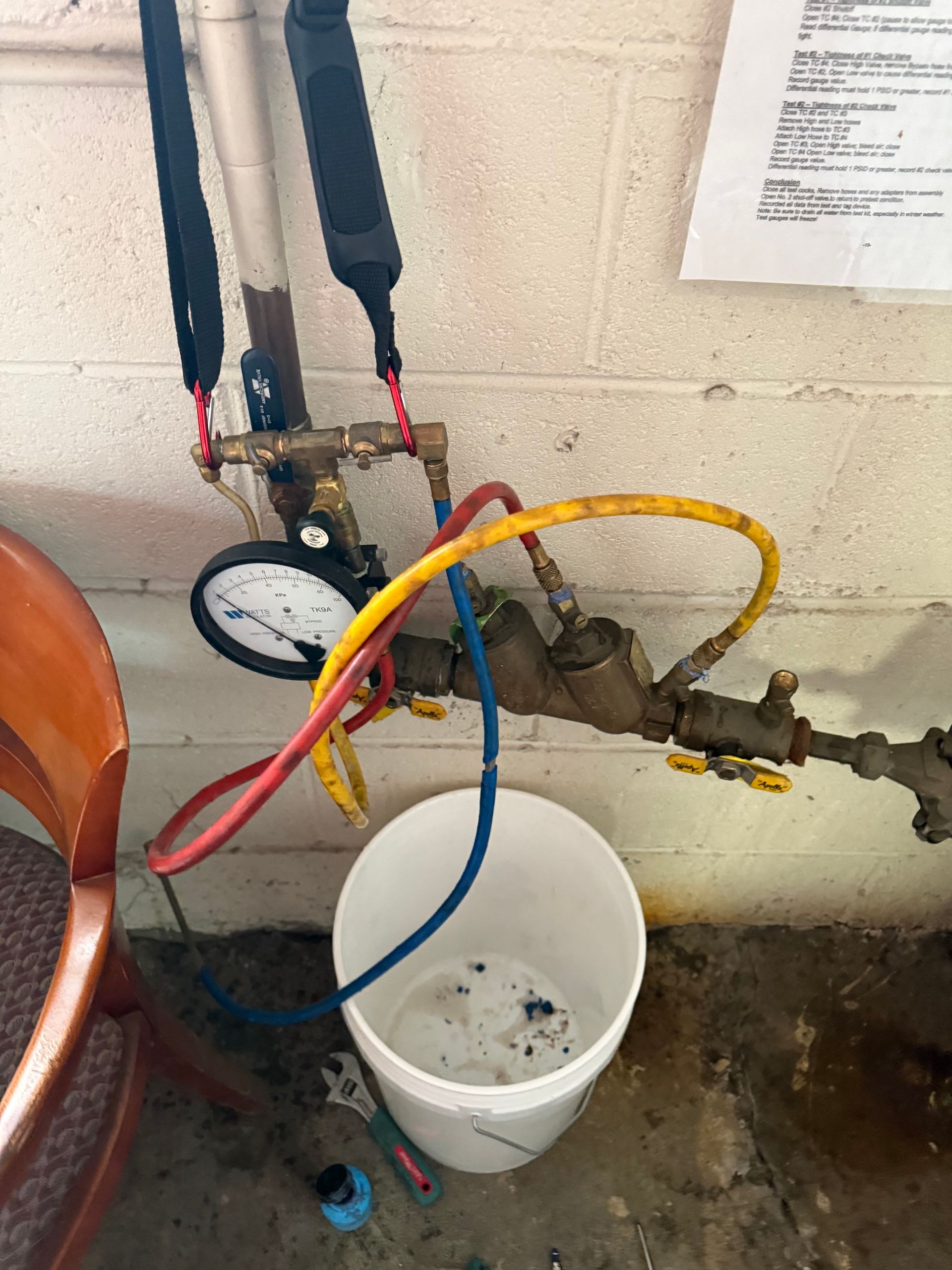 A white bucket with a hose attached to it