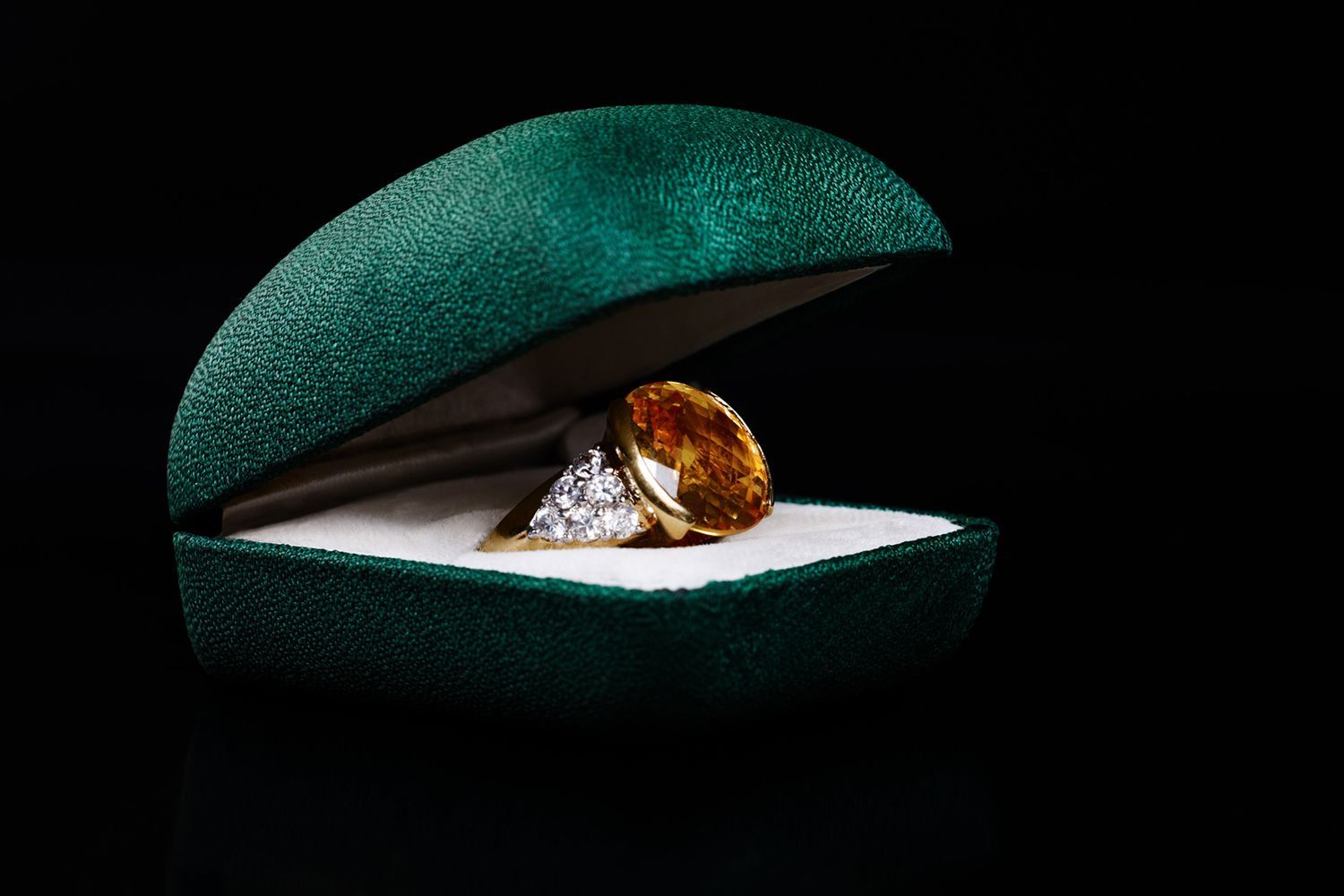 Ring in a green velvet box against a black background. Ring in a green velvet box against a black background.