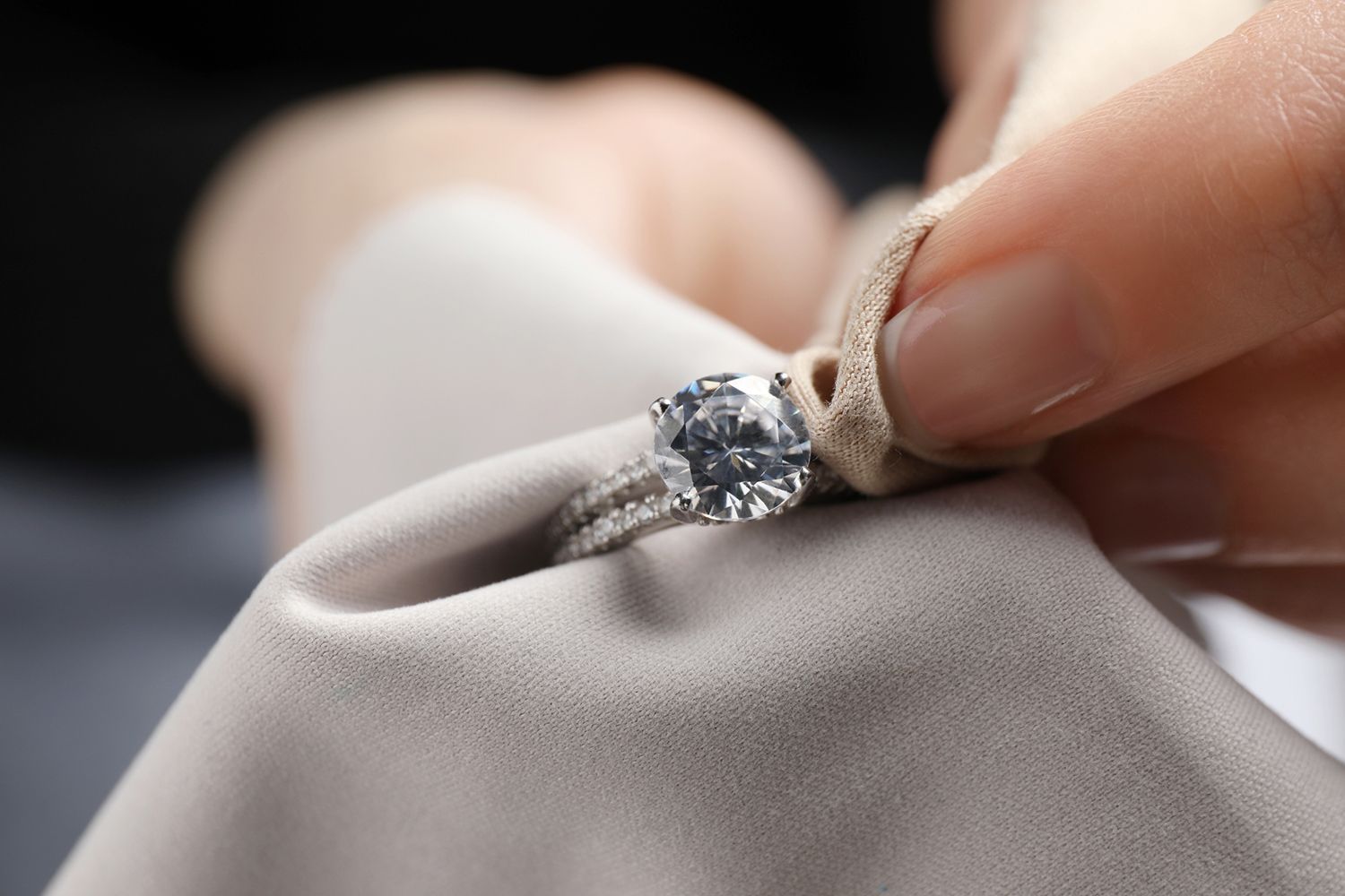 Hand polishing a diamond ring with a soft, beige cloth. Hand polishing a diamond ring with a soft, beige cloth.