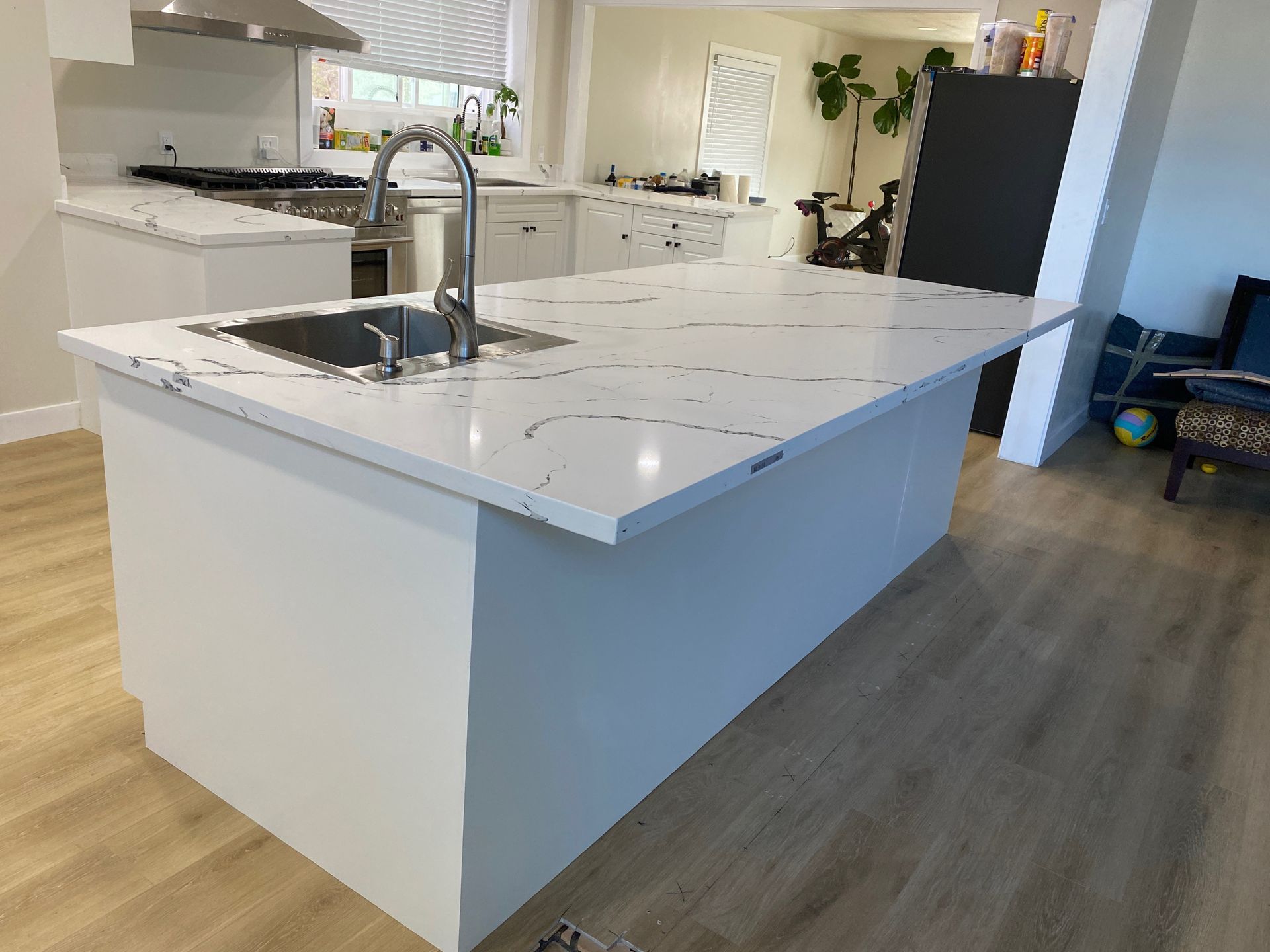 Bright white kitchen with island, stainless appliances, and wood floors