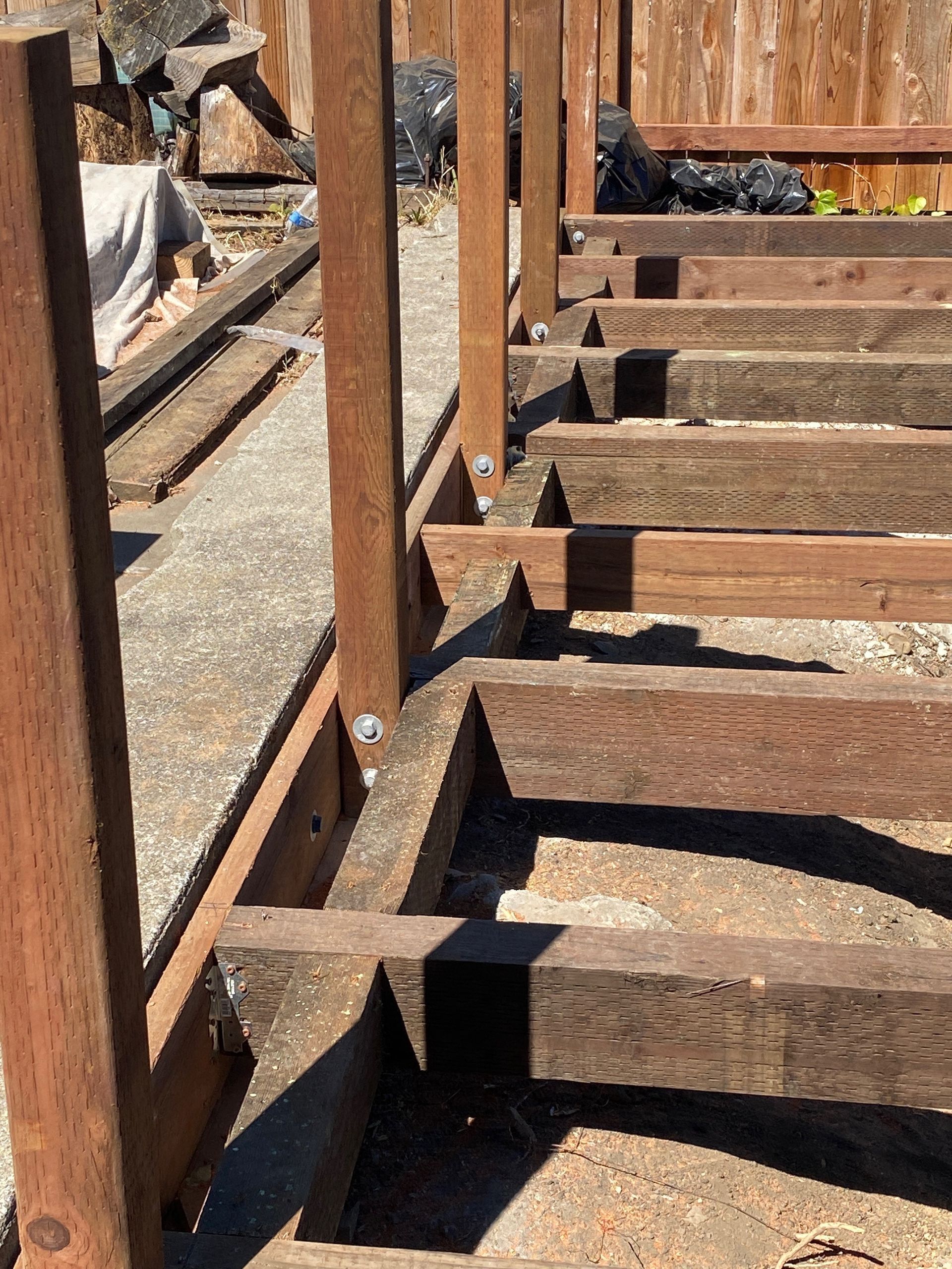 Rusty metal railings and wooden benches in a sunlit outdoor seating area
