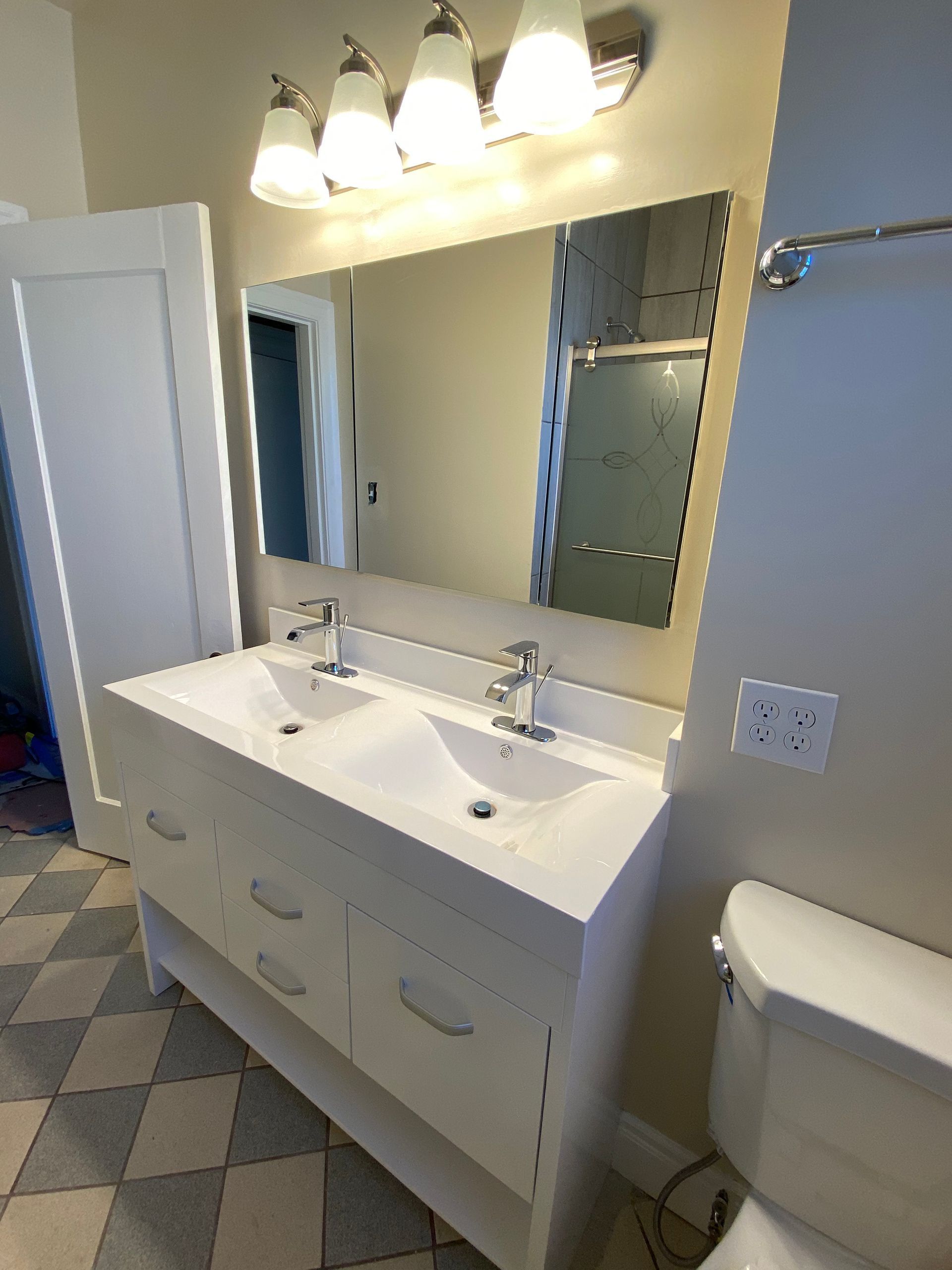 Modern bathroom with glass shower, wood accents, and dark vanity with sink and mirror lights