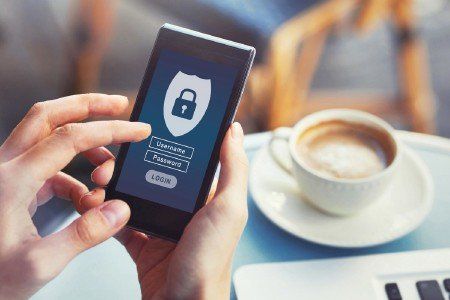 A person is holding a cell phone with a padlock on the screen.