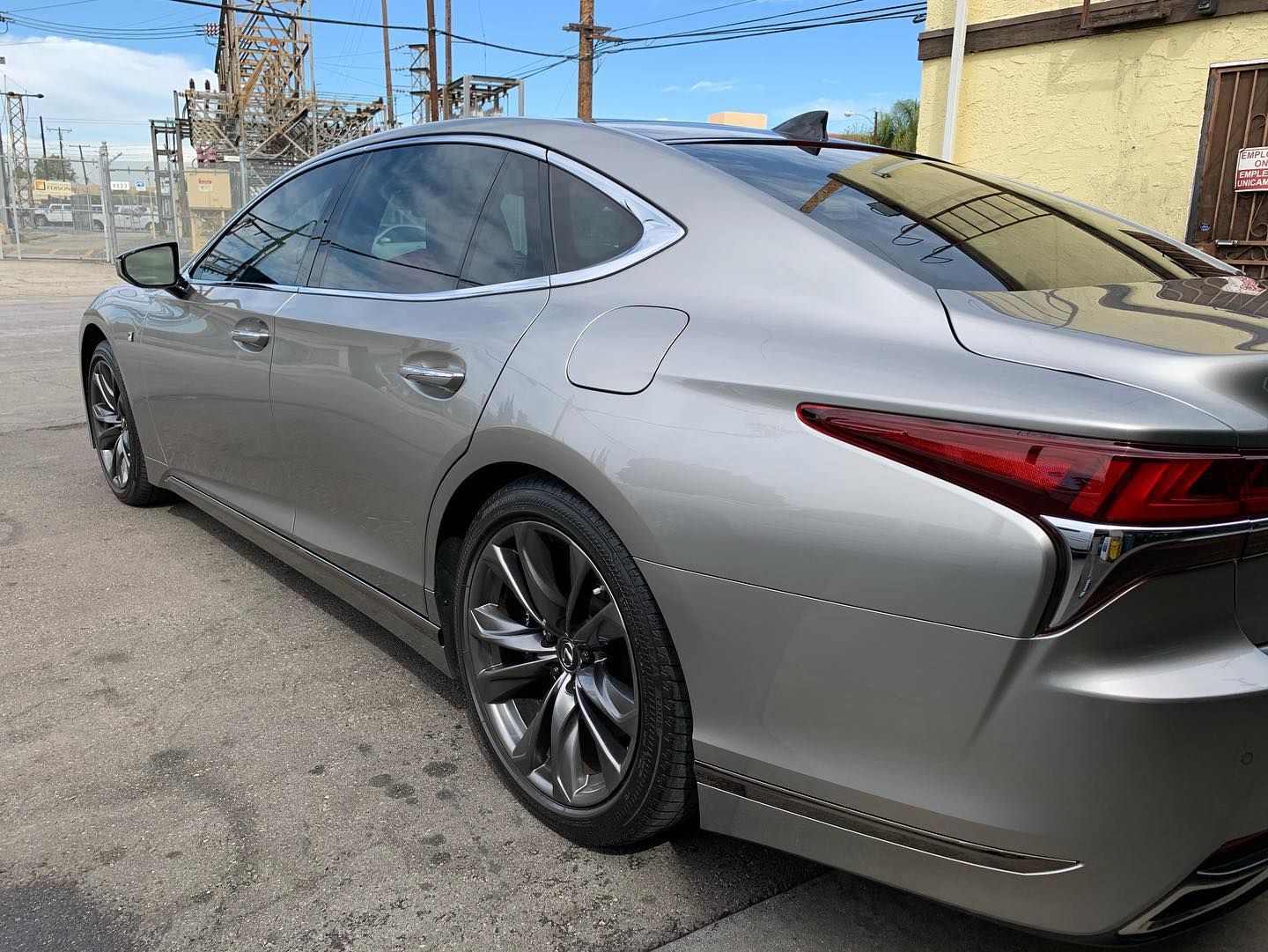 Silver luxury sedan parked outside, side view.