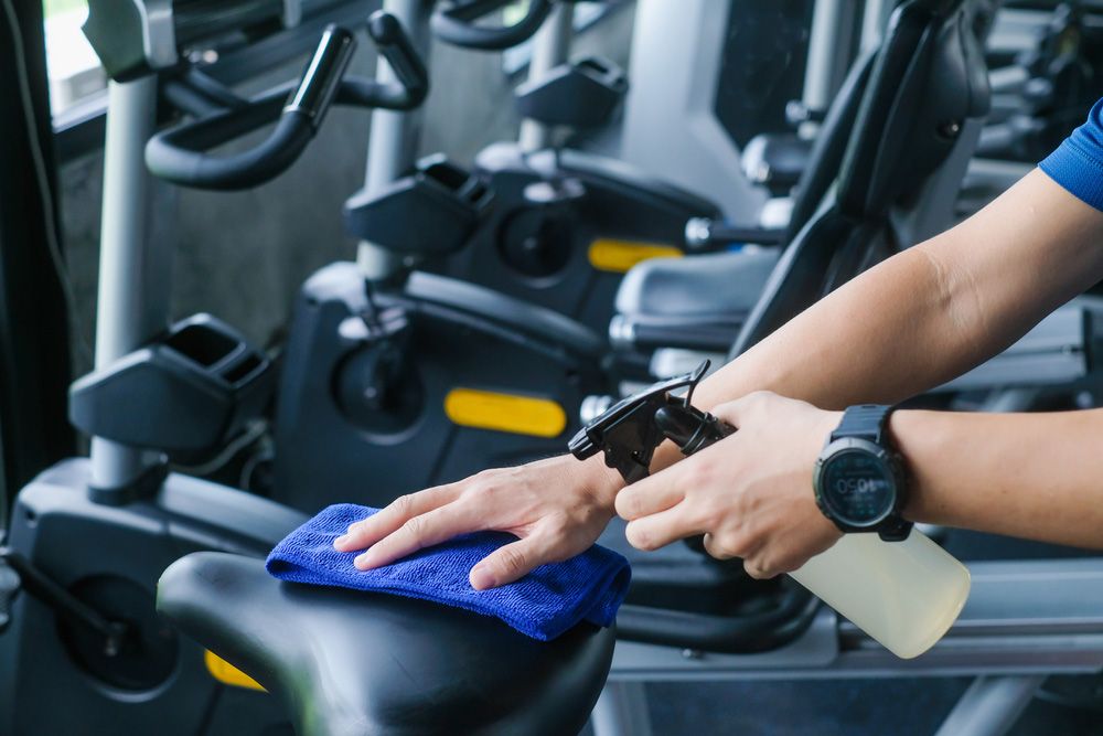 A Person is Cleaning an Exercise Bike in a Gym — Cleaning for Good in Alstonville, NSW