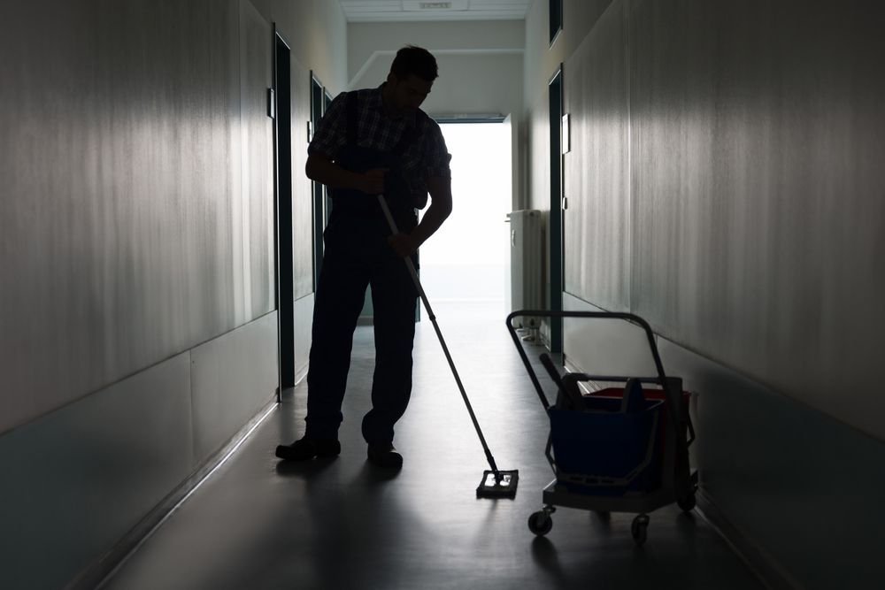 A Man and a Woman Are Cleaning an Office With a Vacuum Cleaner — Cleaning for Good in Brunswick Heads, NSW