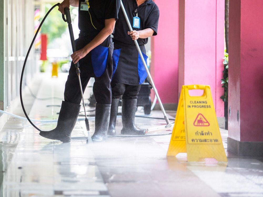 Two Men Are Cleaning the Floor With a High Pressure Washer — Cleaning for Good in Mullumbimby, NSW