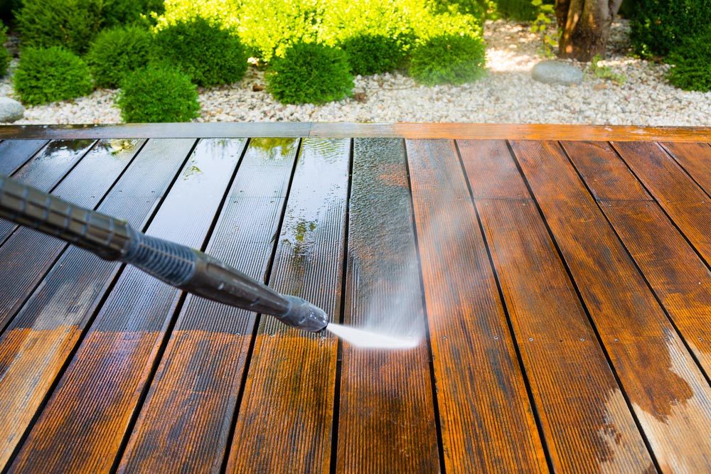 A Deck with bush in the background is being cleaned with a high pressure washer — Cleaning for Good in Byron Bay, NSW