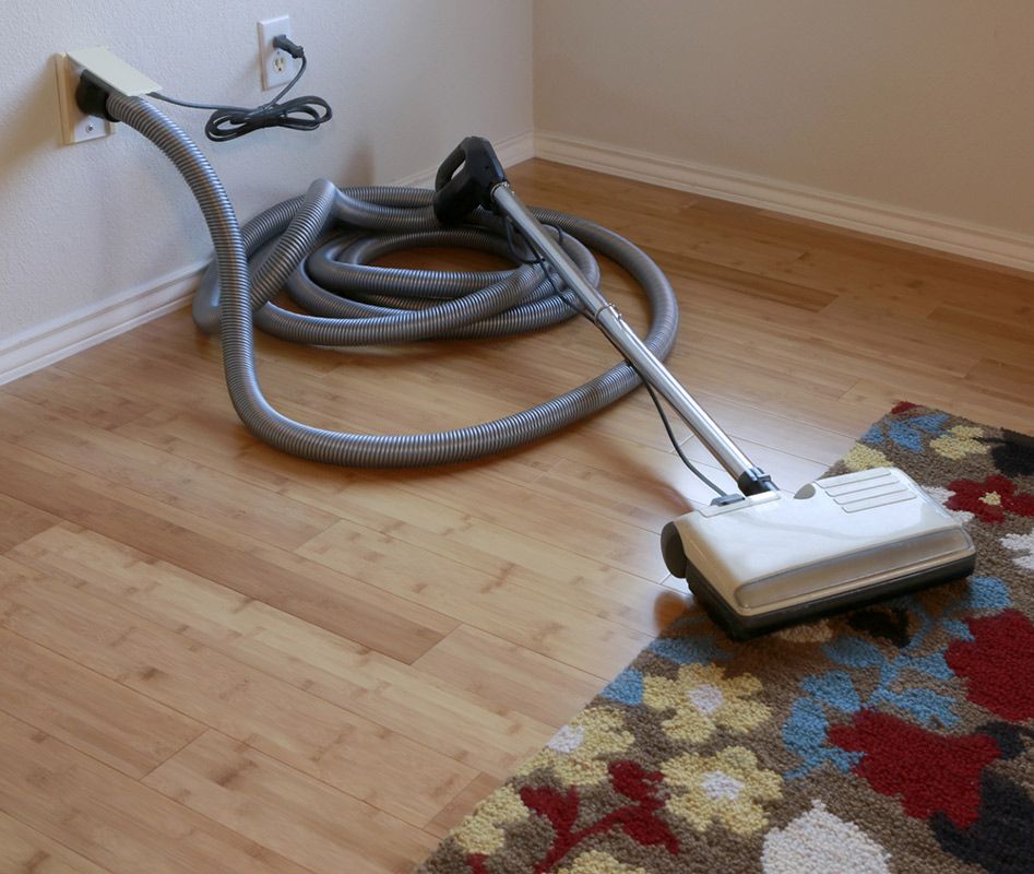 A Vacuum Cleaner is Sitting on the Floor Next to a Rug — Cleaning for Good in Byron Bay, NSW