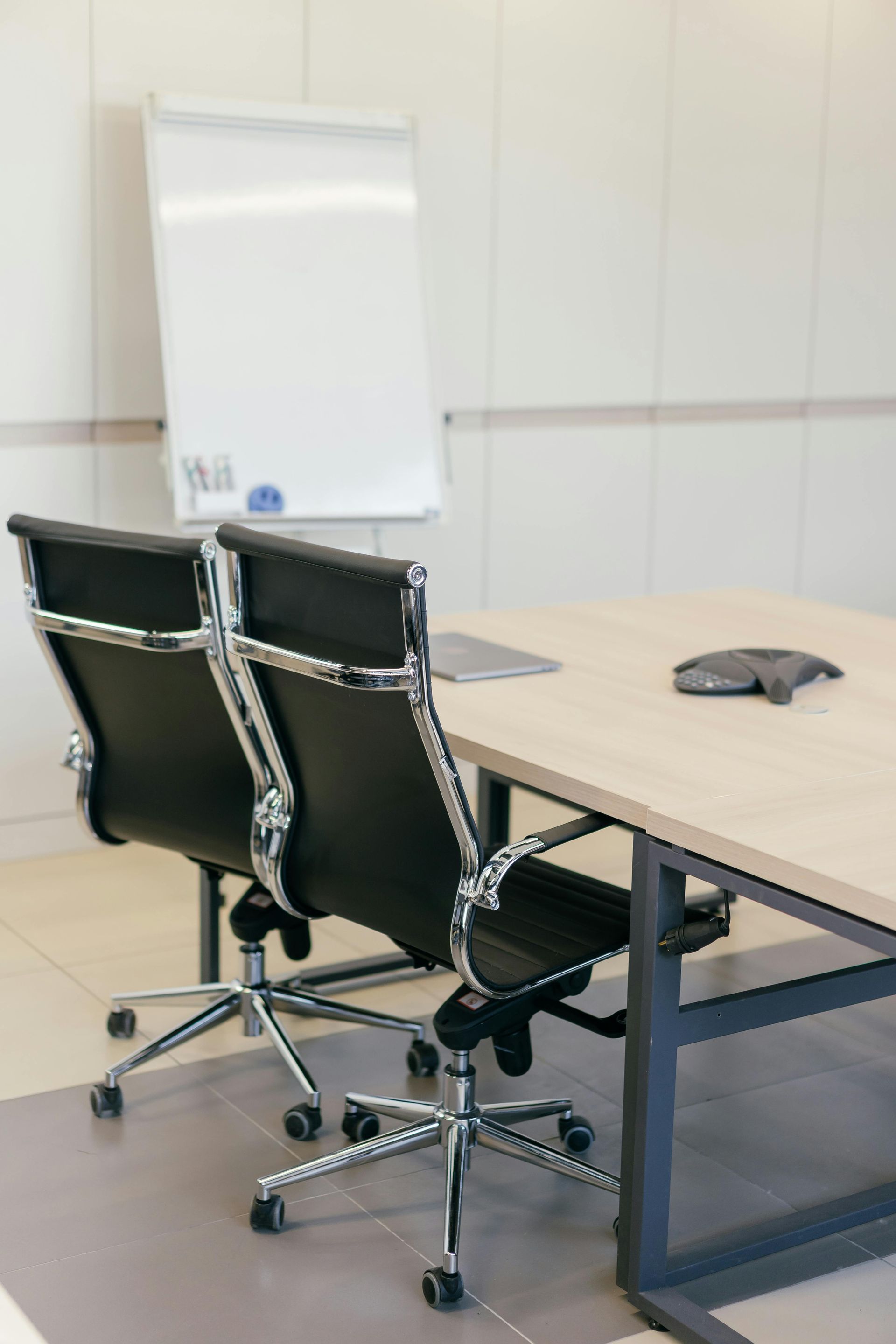 Two black office chairs pushed into table of a meeting room — Cleaning for Good in Byron Bay, NSW
