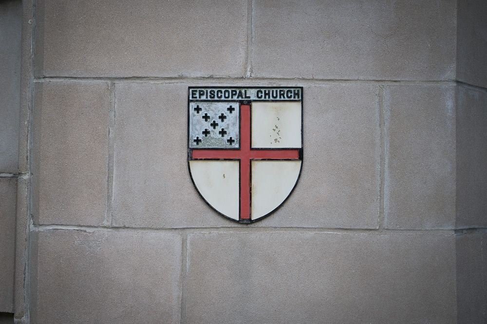 A shield on a brick wall that says episcopal church